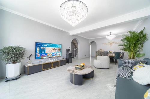 a living room with a couch and a tv at Cloud & Sea Boutique Apartment in Rizhao