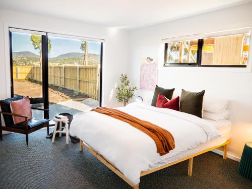 um quarto com uma cama grande e uma varanda em Luxurious Waterfront home in the North of Hobart em Hobart