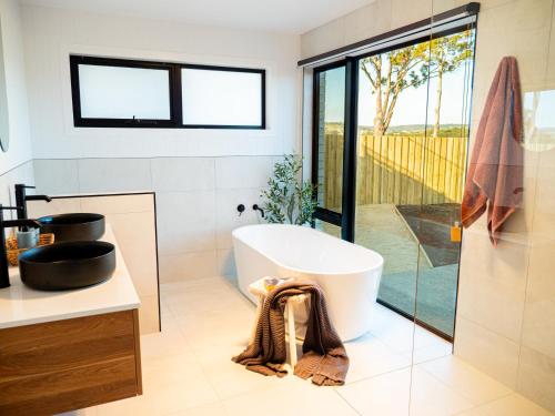 a bathroom with a large tub and a glass shower at Luxurious Waterfront home in the North of Hobart in Hobart