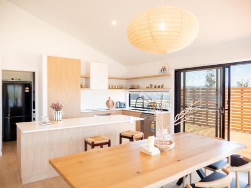 a kitchen and dining room with a wooden table at Luxurious Waterfront home in the North of Hobart in Hobart