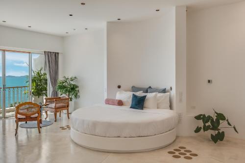 a white bedroom with a large bed in a room at Ampersand Resort in Bophut 