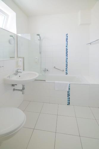 a white bathroom with a sink and a toilet at Hotel Zlatá Hvězda in Litomyšl