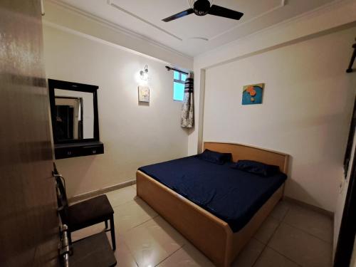 een slaapkamer met een bed en een plafondventilator bij Private room with Sky Garden in Green Bacchus by Walias in Gurgaon