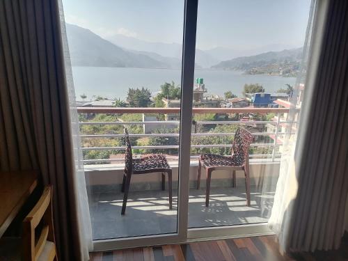 a view of a balcony with two chairs and a table at Urban Boutique Hotel Pokhara in Pokhara