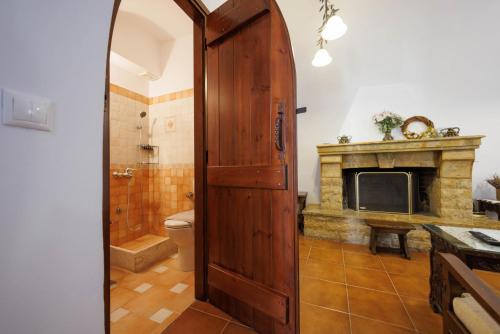 a bathroom with a wooden door and a fireplace at Castello di Haria in Kaloú