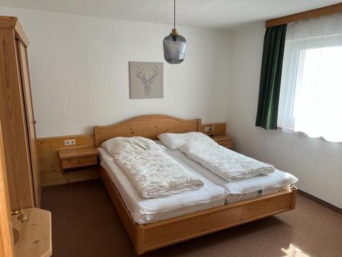 une chambre avec un lit en bois dans une pièce dans l'établissement Chasetta Zum Sigrist, à Galtür