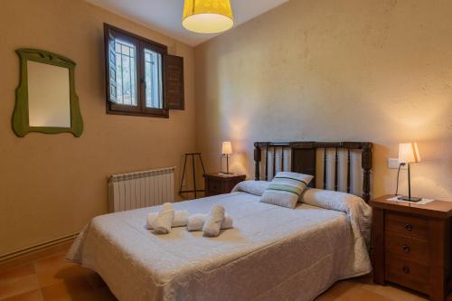 - une chambre avec un grand lit et des serviettes dans l'établissement Casa Rural El Abuelo Luis, à Molinicos