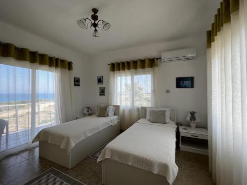 sypialnia z 2 łóżkami i dużym oknem w obiekcie Exquisite Villa with Private Pool in Cyprus w mieście Kirenia