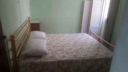ein Schlafzimmer mit einem Bett mit einem weißen Kissen darauf in der Unterkunft Casa Vacanze in Castel del Monte