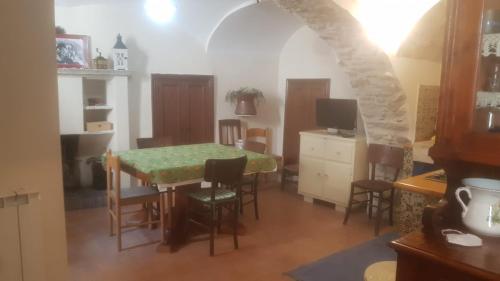 Casa Vacanze في كاستل ديل مونتيه: مطبخ وغرفة طعام مع طاولة وكراسي