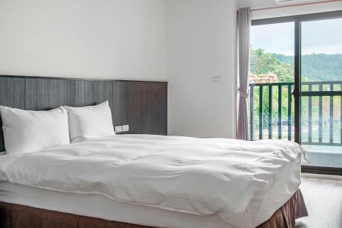 a bedroom with a large bed with a large window at Sun Moon Lake I Love You in Yuchi