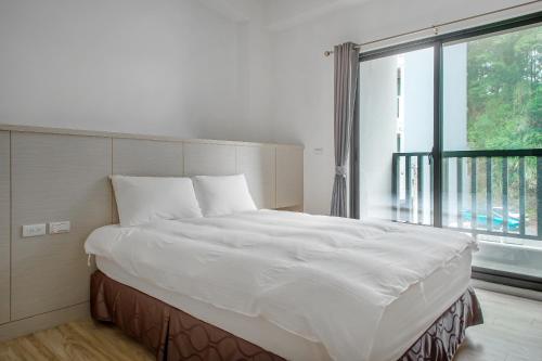 a large bed in a room with a large window at Sun Moon Lake I Love You in Yuchi