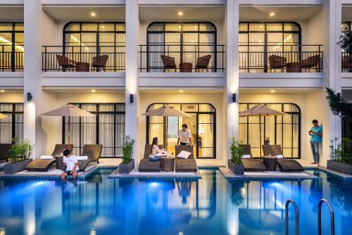 personnes assises autour d'une piscine dans un hôtel dans l'établissement Ai Pai Hotel, à Pai