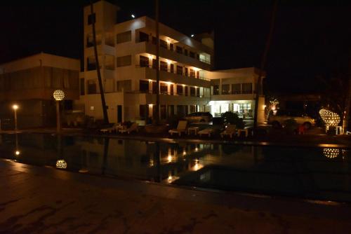 a building with a pool in front of a building at night at New Ocean Hill Hotel in Hikkaduwa