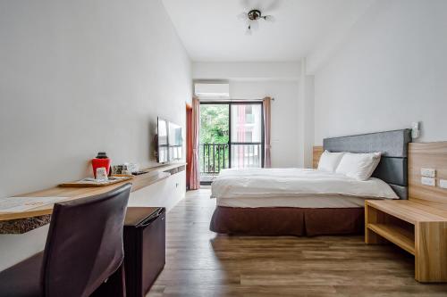 a bedroom with a bed and a desk and a table at Sun Moon Lake I Love You in Yuchi