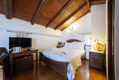 a bedroom with a large bed and a television at Castello di Haria in Kaloú