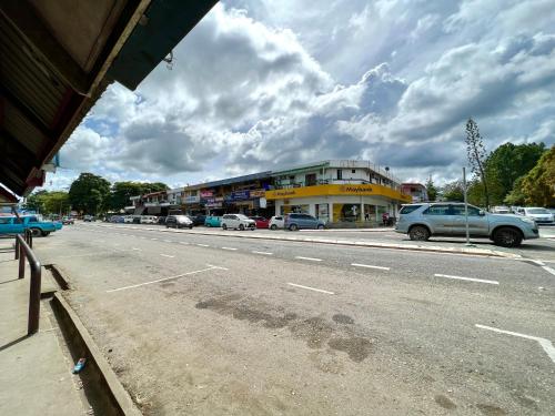 a street with cars parked in front of a building at MJ inn in Ranau
