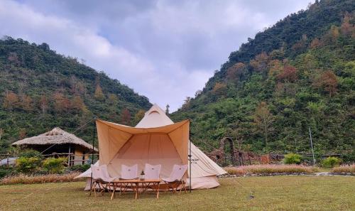 a tent sitting in a field next to a mountain at Nasan Green Farm in Cao Bằng