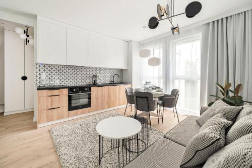 a living room with a couch and a table at Aura 40 City Center by Downtown Apartments in Gdańsk