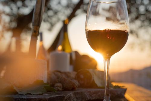 un verre de vin assis au-dessus d'une table dans l'établissement A VIGNA - CASEDDU A PUNTA vue mer et piscine, à Viggianello