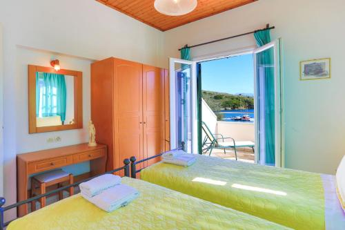 1 dormitorio con 2 camas y balcón en Theophilos Ena, en Ágios Stéfanos
