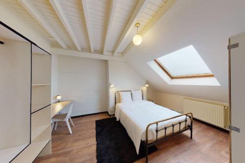 - une chambre avec un lit et une lucarne dans l'établissement Maison 12 chambres en plein coeur du Havre, au Havre