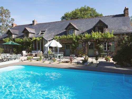 a house with a swimming pool in front of a house at Chambres d'Hotes - La Marmoire in Soudan