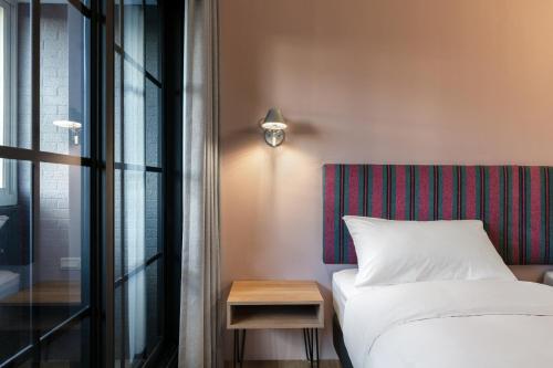 a bedroom with a bed and a table and a window at River Inn Kenting in Hengchun