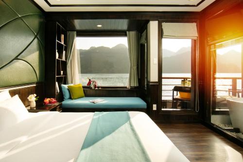 a bedroom with a bed and a window on a boat at Peony Cruises in Ha Long