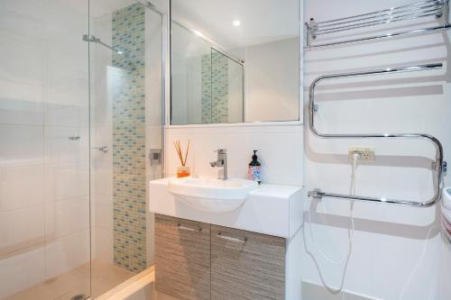 a white bathroom with a sink and a shower at 5@CapeView, beachfront Geographe Bay in Busselton
