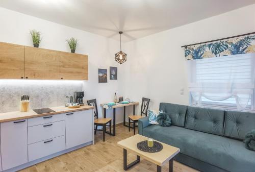 a living room with a couch and a table at Dusznickie Apartamenty z widokiem in Duszniki Zdrój