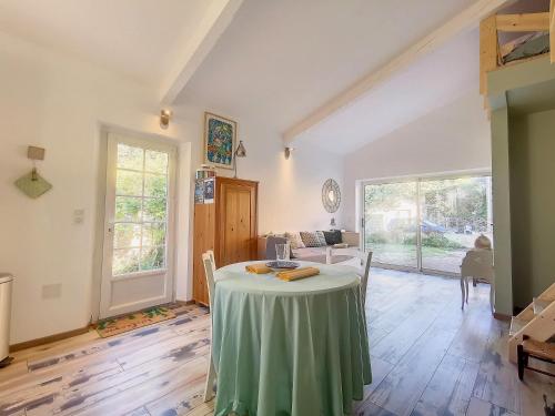 a living room with a table with a green table cloth at Gite l'Odonate, partage des eaux in L'Isle-sur-la-Sorgue