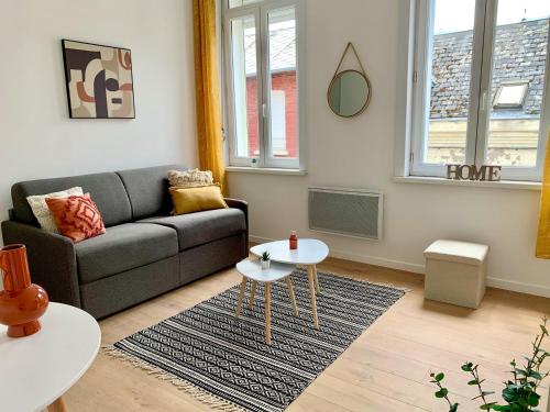 a living room with a couch and a table at Florimond cosy apparts in Saint-Quentin