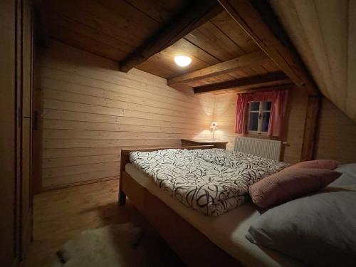 a bedroom with a bed in a wooden room at SPA SPA - Roubenka in Jablonec nad Jizerou