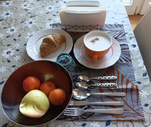 a table with a bowl of fruit and a cup of coffee at B&B Markone Bologna Center in Bologna