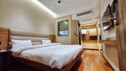 a bedroom with a large white bed in a room at Aura Rooms in Dehradun
