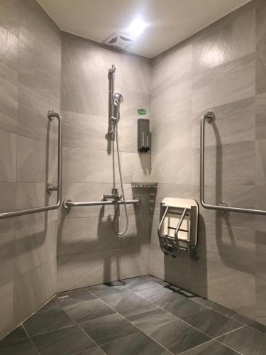 a public bathroom with a shower and a phone at Green Hotel - Chiayi in Chiayi City