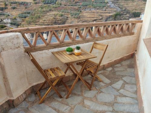 stół i krzesła na balkonie z widokiem w obiekcie La Castaña y la Uva 