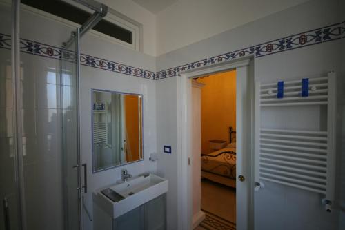 ein Bad mit einem Waschbecken und einem Spiegel sowie ein Schlafzimmer in der Unterkunft Irene's Home The Residence in Rom