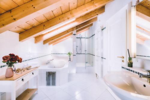 La salle de bains blanche est pourvue d'une baignoire et d'un lavabo. dans l'établissement Haus Miele, à Garmisch-Partenkirchen