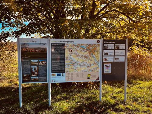 a sign sitting in the grass next to a tree at Ferienwohnung I Beck-Bräu nahe Bamberg in Lisberg