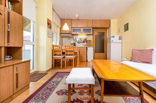 a living room with a table and a kitchen at Quiet apartment near the center in Plovdiv
