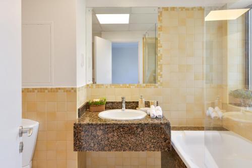 a bathroom with a sink and a toilet and a mirror at Luxury JBR · Sea View · 5* Beach Resorts Access! in Dubai