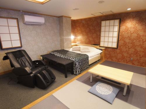 1 dormitorio con cama, escritorio y silla en ホテルラパンセ Adult Only, en Saitama