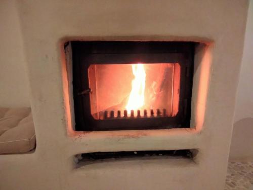 a fire is burning in a brick oven at Casa Cueva El Naranjo Rocabella in El Chorro