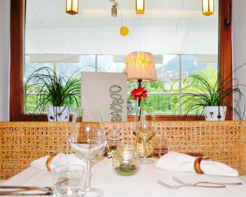 a table with wine glasses and a lamp on it at Hotel Bamboo in Coldrano