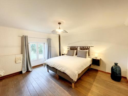 a bedroom with a large bed and a window at Au regard des biches 