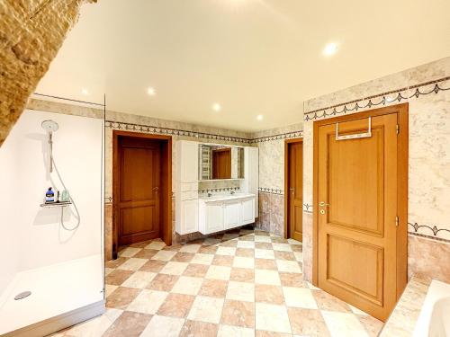 a kitchen with a tile floor and a wooden door at Au regard des biches 