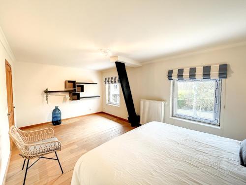 a bedroom with a bed and a chair and a window at Au regard des biches in Sovet