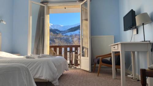 a bedroom with a bed and a television and a balcony at Le Brunet in Saint-Jacques-des-Blats